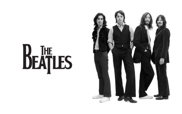Paul Mccartney standing with band members in a classic black and white portrait