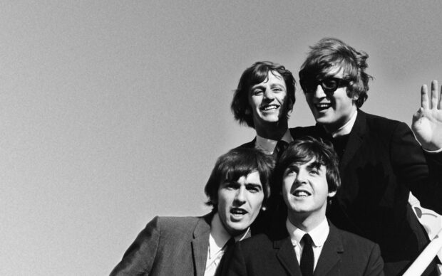 The Beatles band members including Paul Mccartney posing together in a classic black and white photo