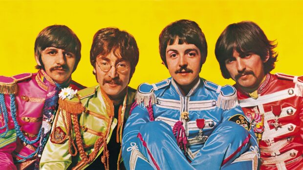 Paul Mccartney dressed in colorful vintage military style uniforms with band members on a bright yellow background