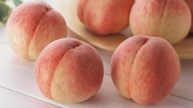 Fresh ripe peach fruit on a wooden table with soft natural lighting