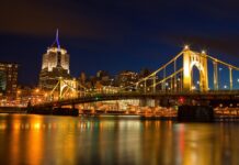 Pittsburgh skyline at night featuring Pennsylvania architecture and lit suspension bridge