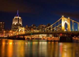 Pittsburgh skyline at night featuring Pennsylvania architecture and lit suspension bridge