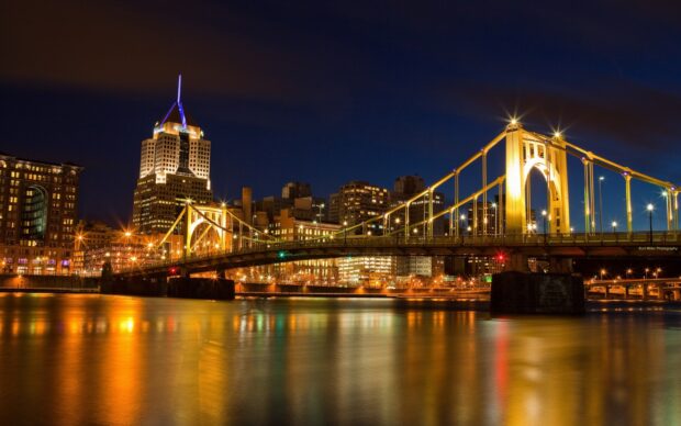 Pittsburgh skyline at night featuring Pennsylvania architecture and lit suspension bridge