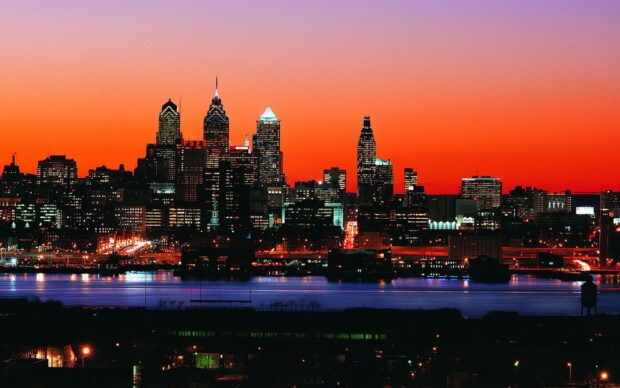 City skyline at sunset in Pennsylvania with vibrant orange sky and illuminated buildings