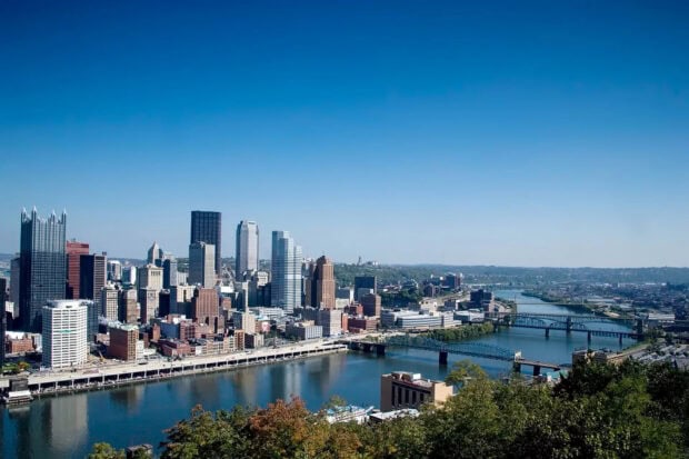 Downtown Pennsylvania skyline with river and bridges under clear blue sky
