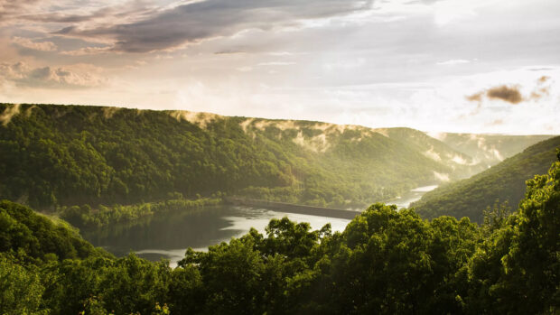 Lush Pennsylvania hills surround a peaceful river valley under a cloudy sky