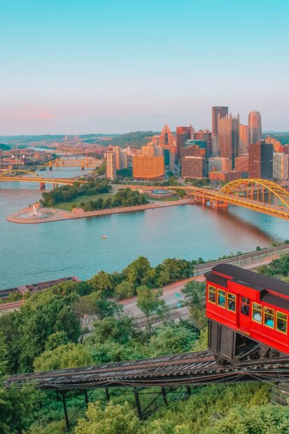 Red incline railway car climbing hill over green trees in Pennsylvania