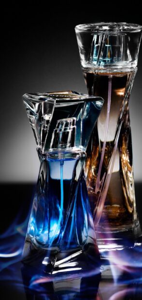 Blue and amber perfume bottles with a flame effect on a dark surface