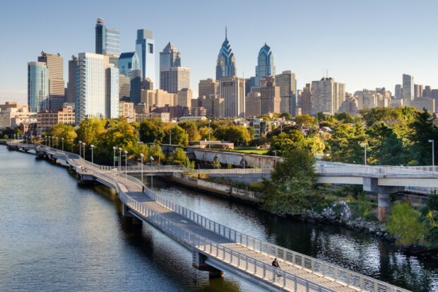 A cityscape of Philadelphia Pennsylvania with a river and modern skyscrapers in the background