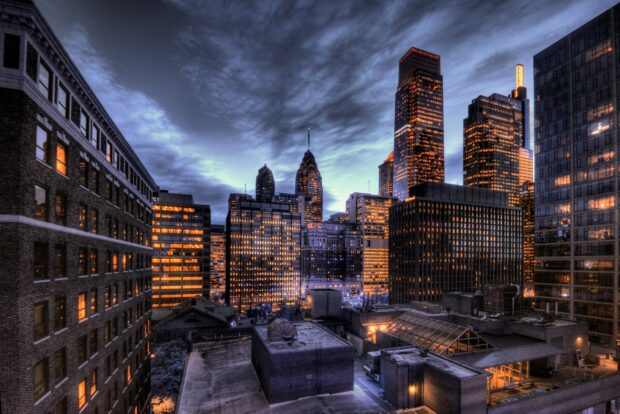 Philadelphia cityscape featuring tall buildings and glowing windows at dusk