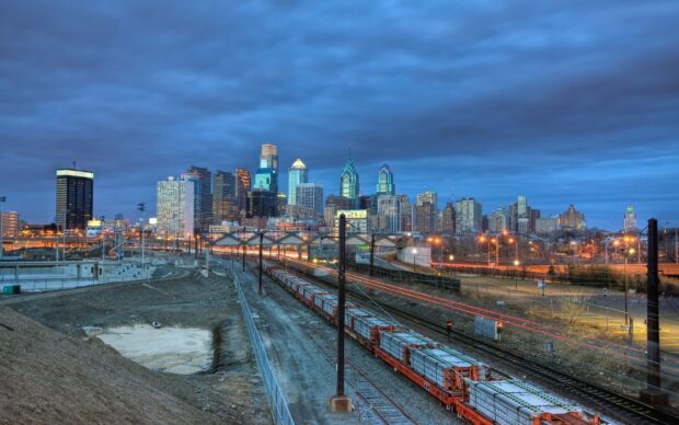 Philadelphia Pennsylvania cityscape with railway tracks under a cloudy sky at dusk