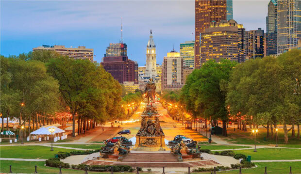 The Philadelphia cityscape at twilight with historic architecture and green trees in Pennsylvania