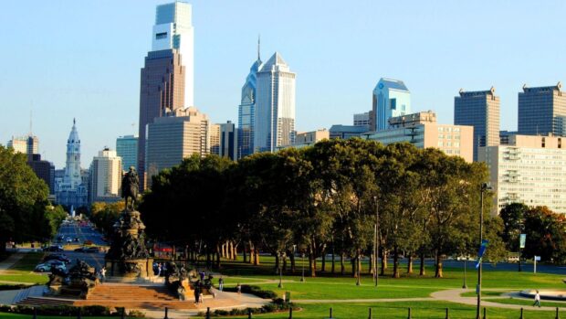 The Philadelphia cityscape with Benjamin Franklin Parkway statue and green park in Pennsylvania