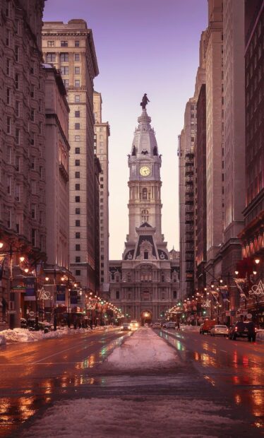 Philadelphia Pennsylvania City Hall tower with snow on the street in winter evening