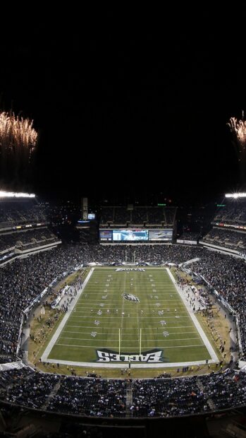A packed stadium with Philadelphia Eagles football game under fireworks at night