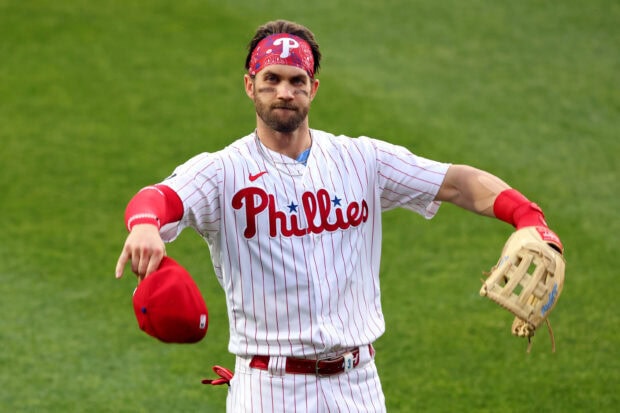 A Philadelphia Phillies player wearing a red bandana and holding a red cap on the baseball field