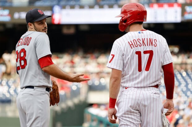 A Philadelphia Phillies player wearing helmet number 17 and another baseball player in conversation during a game