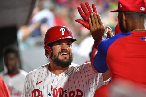 Philadelphia Phillies player celebrating during a game with a high five in the dugout