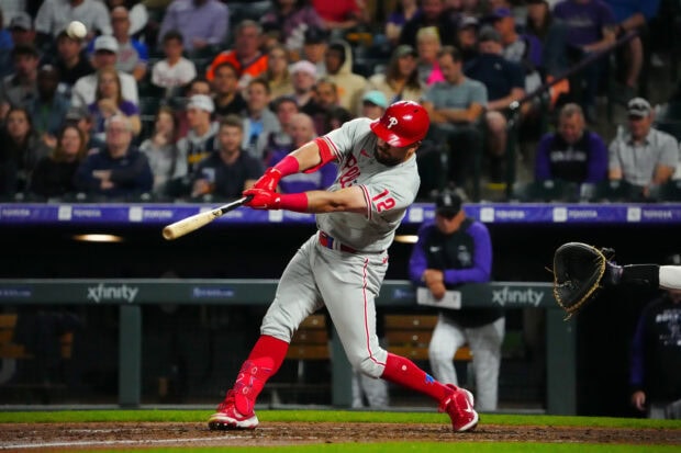 Philadelphia Phillies player swinging at the pitch during a baseball game in front of a crowd