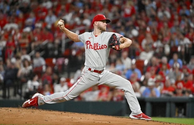 A Philadelphia Phillies player pitching during a baseball game with a packed stadium in the background