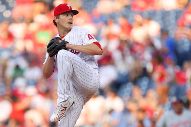 A Philadelphia Phillies player preparing to pitch during a baseball game in a crowded stadium