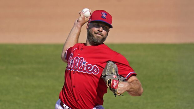 Philadelphia Phillies player pitching a baseball in a game wearing a red uniform