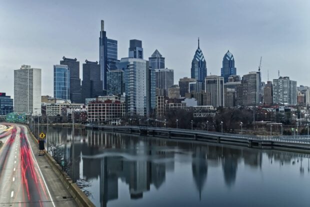 Philadelphia city skyline with modern buildings reflecting in the river at dusk