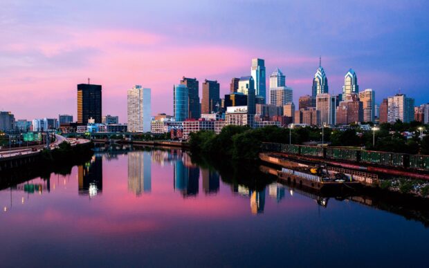 Philadelphia skyline with river reflections under a pink sky at sunset