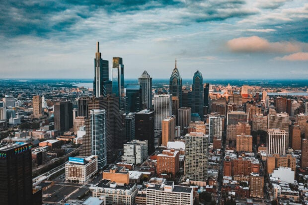 Philly skyline with tall modern buildings under a partly cloudy sky