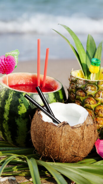 Fresh pineapple drink served in a hollow pineapple on a tropical beach