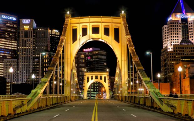 Night view of Pittsburgh bridge and city skyline with illuminated skyscrapers