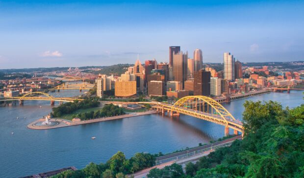 A panoramic view of Pittsburgh cityscape featuring famous bridges and urban skyline