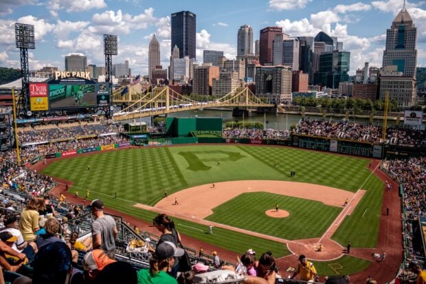 View of Pittsburgh stadium with city skyline and bridge on a sunny day