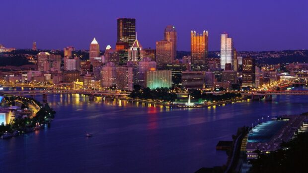 Night view of Pittsburgh city skyline with river and illuminated buildings at dusk