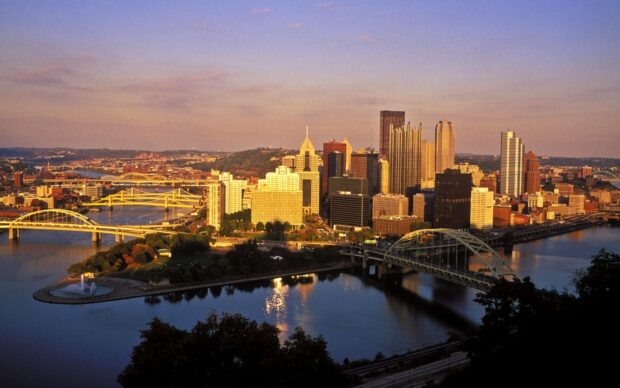 Pittsburgh city skyline at sunset with bridges over the river and urban buildings in view