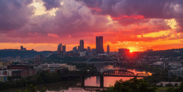 Pittsburgh skyline at sunset with colorful clouds and river view