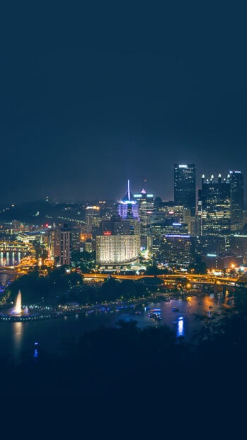 Night skyline of Pittsburgh city with illuminated buildings and river view