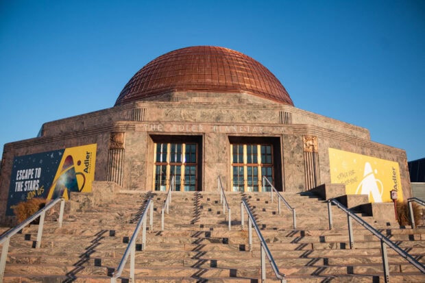 The Adler planetarium building with a large dome under a clear blue sky