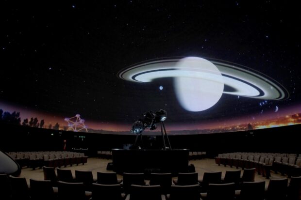 A planetarium showing a detailed planetarium with a projection of Saturn and stars on the dome