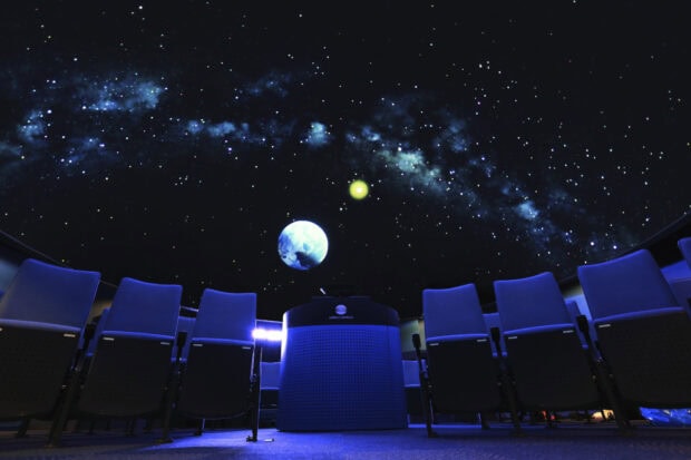A planetarium showing a detailed planetarium with stars and planets projected on the dome