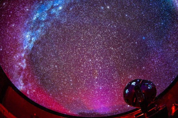 A planetarium showing a detailed view of the night sky filled with stars and cosmic objects