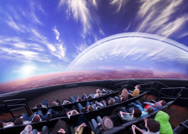 Visitors enjoying a planetarium dome showing a detailed planetarium display