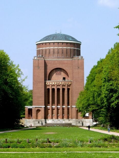 Historic planetarium building with green lawn and trees on a sunny day