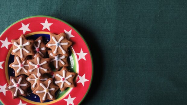 Star shaped cookies on a festive plate with star decorations on a green surface