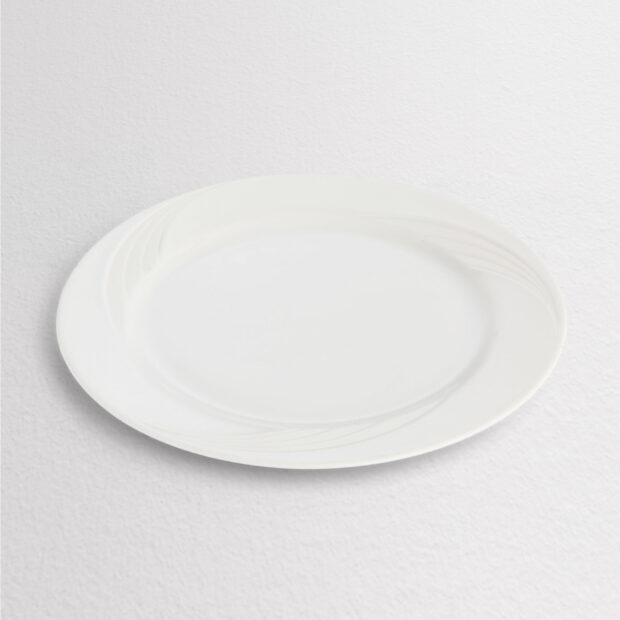 White ceramic plate with subtle wave pattern on a textured surface