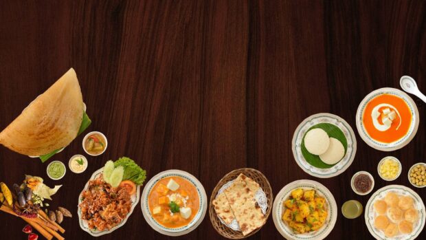 Delicious Indian plate featuring dosa curry and various traditional dishes on a wooden table