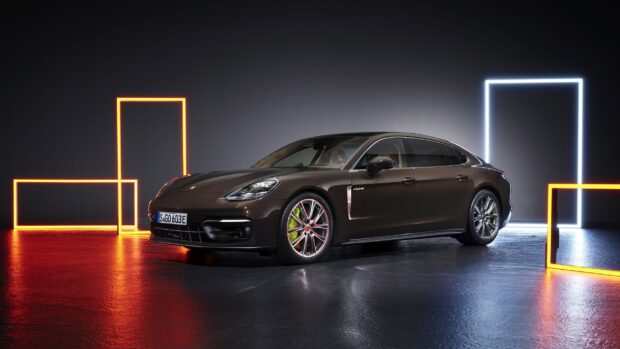 A Porsche Panamera electric car parked indoors with illuminated geometric frames in the background