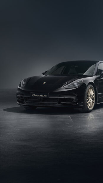 Black Porsche Panamera car parked on a dark floor with detailed front view and golden wheels