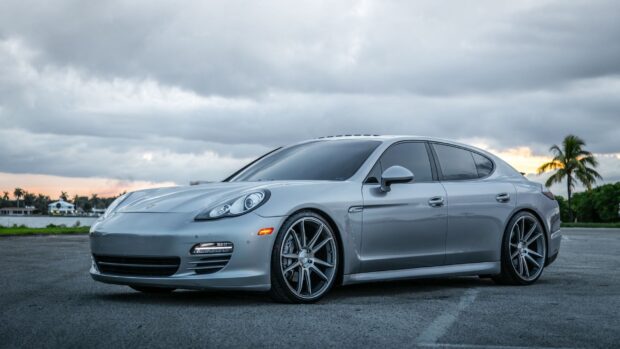 Silver Porsche Panamera parked on an empty road under a cloudy sky