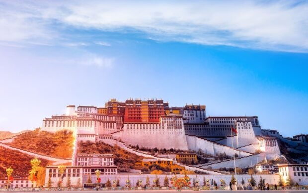 The view of Potala Palace in Tibet under a clear blue sky at sunset